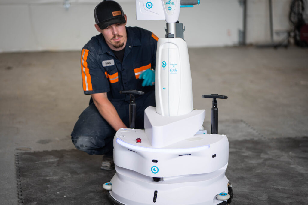 A WaySolutions technician inspects an advanced i-mop XL autonomous robotic floor scrubber during a routine maintenance service in Layton, Utah.